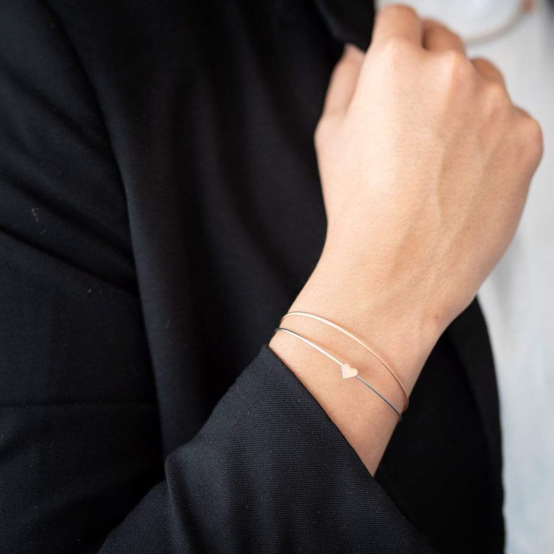 Vrouw draagt goudkleurige Thinking of You armband met hartje | CLIC by Suzanne
