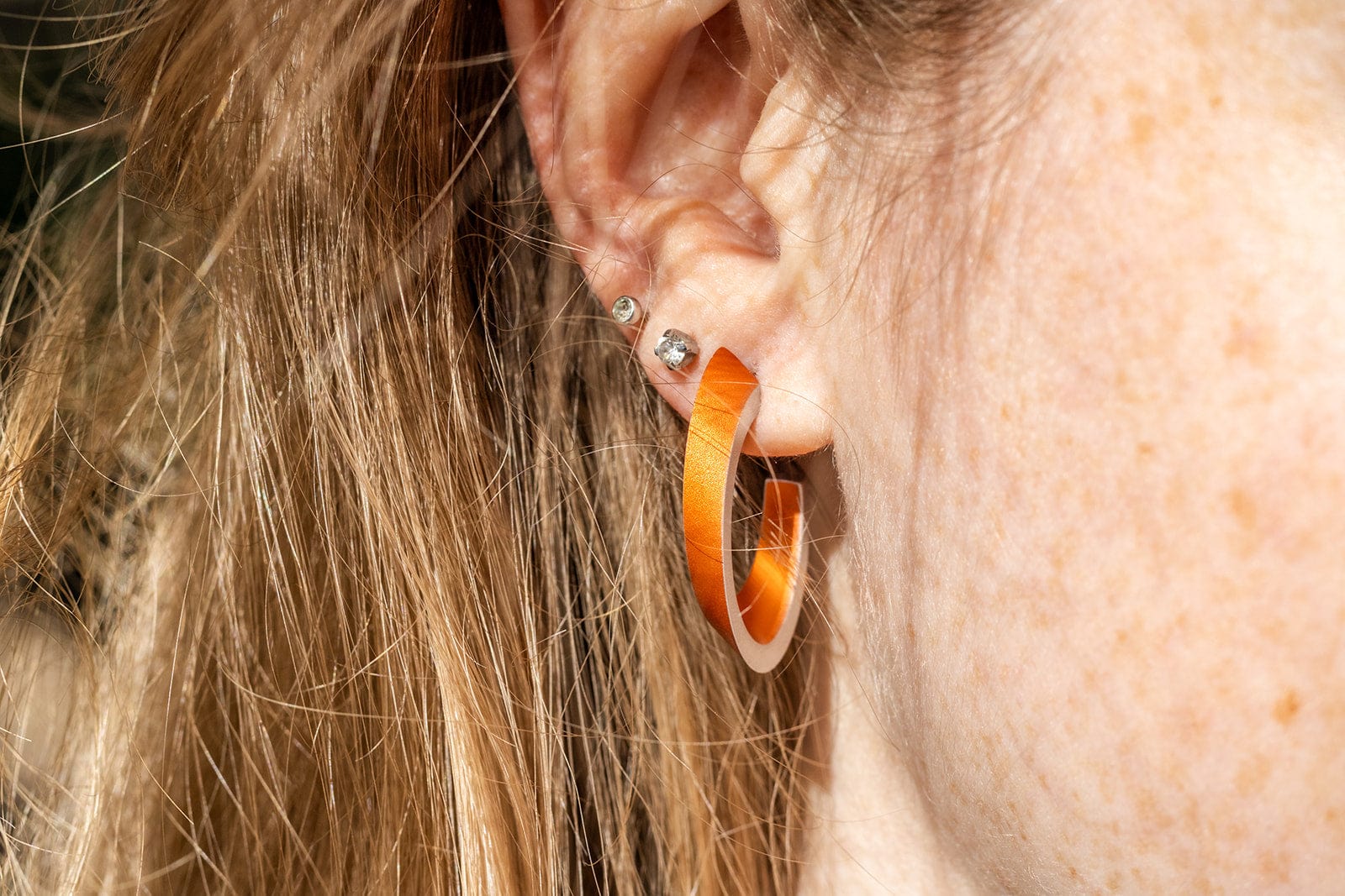 Lifestyle shot OLIVIA hoop earrings orange | hypoallergenic jewelry in aluminum and stainless steel | CLIC by Suzanne